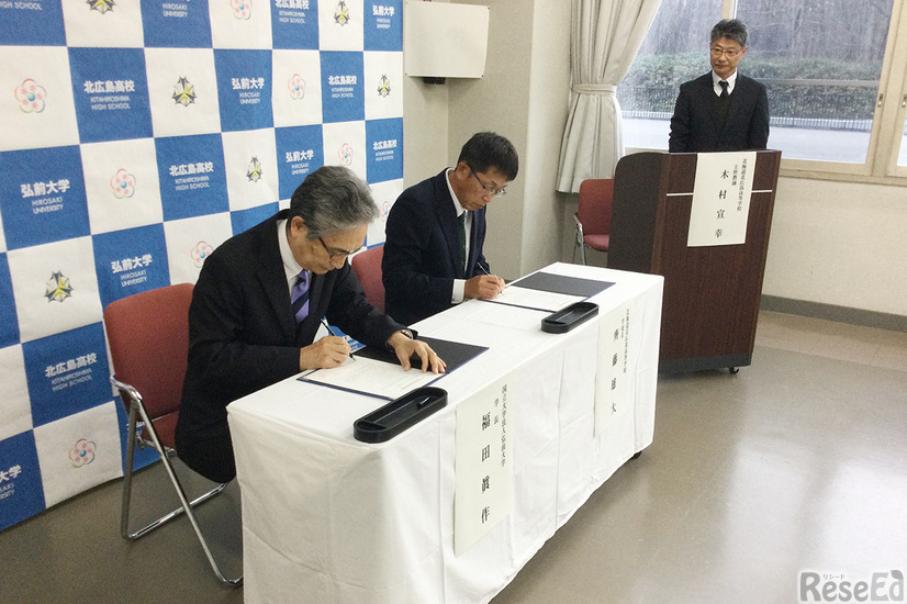 （左から）協定書に署名する福田学長（弘前大学）と齊藤校長（北海道北広島高校）