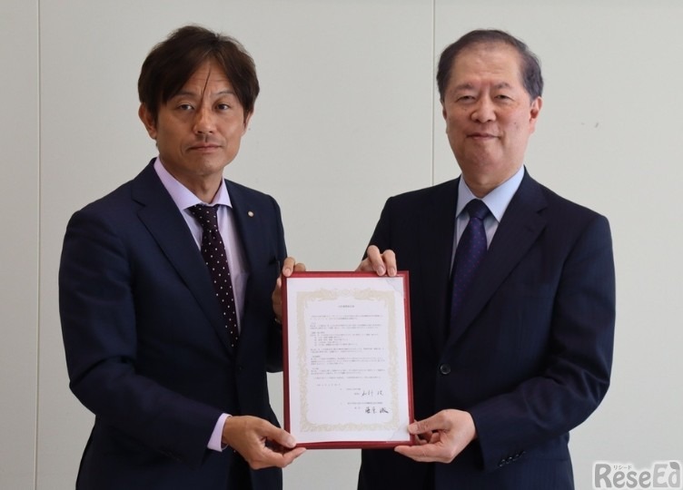 締結した協定書を掲げる（左から）加計理事長、藤原館長