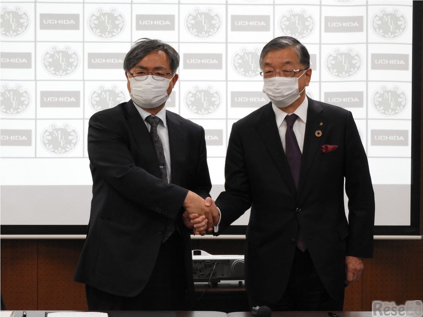 握手を交わす宮城教育大学の村松隆学長（左）と内田洋行の大久保昇社長（右）