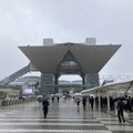 雨の中、多くの人々が会場へ。期待が高まる。