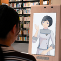 近畿大学中央図書館の受付窓口に設置したアバターディスプレイ