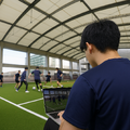 新座グラウンドで学生がサッカーのデータを分析 ※人物は生成AIで挿入しました
