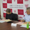 協定書に署名する小檜山学長（左）と金理事長・学長（右）