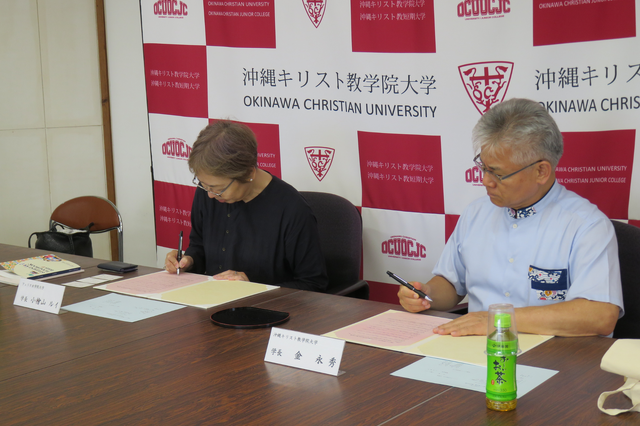 協定書に署名する小檜山学長（左）と金理事長・学長（右）