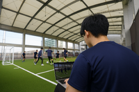 新座グラウンドで学生がサッカーのデータを分析 ※人物は生成AIで挿入しました